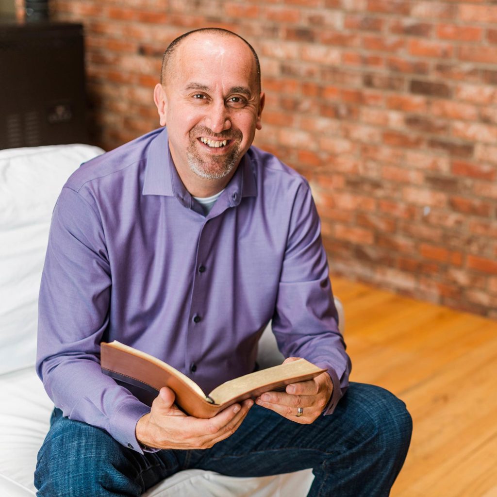 Marcus Wick smiling and holding a Bible